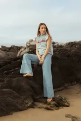 Blusa sin mangas a rayas verticales blancas y verdes, con cuello alto fruncido y volados decorativos en escote y hombros, con terminaciones en rojo.