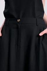 Falda larga negra de lino, corte recto y bolsillos laterales.