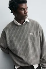Sudadera gris con rayas verticales blancas, cuello redondo, manga larga y bordado con texto en el pecho.