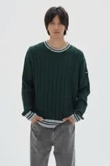 Buzo tejido de ochos color verde oscuro, con cuello a la base y rayas contratono en puños y cuello.