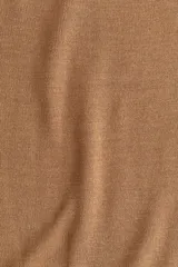 Buzo de punto fino color camel, de corte holgado con escote redondo y mangas raglán. Presenta cuello, puños y bajo acanalados.