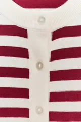 Chaqueta de punto color crema con rayas horizontales color borgoña, de cuello redondo y manga larga. Cierre frontal con botones.