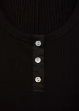 Vestido midi negro de punto canalé, sin mangas, con cuello redondo y cierre frontal con botones.