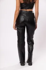 Pantalón de tiro alto negro de gabardina strech metalizada, con bolsillos y cierre frontal con cremallera y botón.