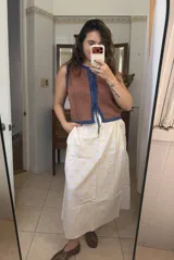 Falda midi blanca con lunares amarillos y bolsillos laterales.