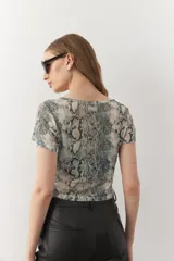 Top de manga corta con cuello a la base, en print animal y tejido transparente.