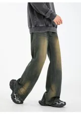 Pantalón de jean unisex modelo Oxford, color verde oscuro con efecto desgastado en tonos marrones/tostados. Presenta un corte recto o ligeramente acampanado, pinzas en los tobillos y elástico en la parte trasera de la cintura.