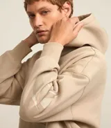 Saco beige de algodón y poliéster con capucha, bolsillo canguro, manga larga ajustada con estampa de llamas lateral, bajo ajustado y estampa lettering localizada.