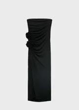 Vestido largo negro sin mangas, con escote strapless, detalle de flores 3D en la cintura, abertura lateral en la falda y corte ajustado.