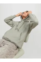 Hoodie tipo canguro color gris mineral, de manga larga con capucha y fit regular. Cuenta con un bolsillo y estampado de goma con tacto suave. Tejido Loop Back.