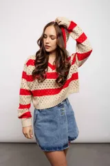 Buzo de punto calado a rayas horizontales en tonos beige y negro, con capucha y corte holgado.