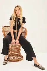 Pantalón palazzo negro de tiro alto con cintura elastizada y bolsillos diagonales.