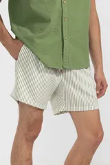 Short de baño a rayas verticales color beige y blanco, con cintura elástica ajustable con cordón, bolsillos laterales y trasero con cierre, y logo bordado en la pierna.