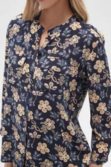 Camisa de viscosa con estampado floral en tonos azul, beige y blanco. Tiene cuello mao, mangas largas y bolsillos en el pecho.