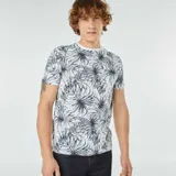 Remera blanca con estampado de hojas de palmera en tonos verde y azul.