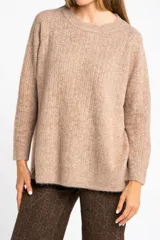 Sweater color beige de tejido texturado, con cuello redondo y mangas largas.