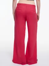 Pantalón ancho color blanco, de lino y viscosa, con tajos y lazos en la botamanga.