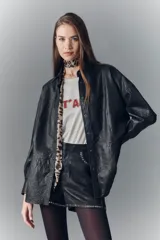Camisa de cuero ovino negro con efecto arrugado, de moldería amplia, con cuello camisero y botones a presión con logo.