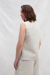 Chaleco color crema de lino, con cuello mao, cierre frontal con botones y bolsillos ojal a contratono.