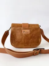 Cartera bandolera de cuero color camel, con correa larga regulable y cierre con solapa y hebilla.
