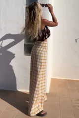 Pantalón de lino italiano con estampado escocés en tonos marrón, beige, amarillo y naranja. De tiro medio alto y corte oxford.