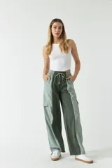 Pantalón verde con corte ancho, bolsillos laterales y cintura ajustable con cordón.