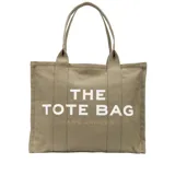 Bolso tote grande de lona color beige con asas de mano y cierre superior con cremallera. Estampado frontal con la leyenda "THE TOTE BAG MARC JACOBS" en letras blancas.