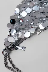 Cartera plateada con lentejuelas y cadena metálica.