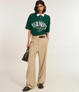 Camisa polo verde oscuro de algodón con cuello blanco contrastante, cierre de botones y mangas cortas. Estampa frontal con lettering "Vermont Valley".