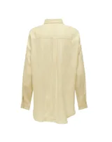 Camisa de lino y viscosa color amarillo pastel con rayas verticales blancas. Presenta cuello clásico, cierre frontal de botones y bolsillo de parche en el pecho. Las mangas son largas y se pueden remangar con presilla.