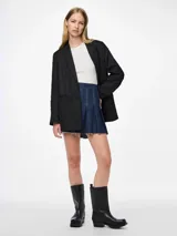 Blazer negro con cuello clásico, cierre de botones y bolsillos frontales. Tiene tachas plateadas en el frente y las mangas.