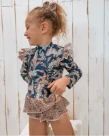 Conjunto de baño de lycra con protección UV, estampado con flores y leopardos. Incluye remera de manga larga con volados en los hombros y bombacha con volados.