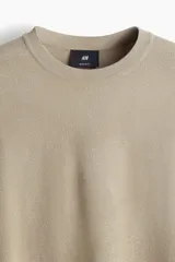 Remera color beige de punto suave con cuello redondo con ribete acanalado y bajo recto.