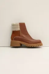Bota tipo chelsea negra con detalles de tela de corderoy y suela gruesa.