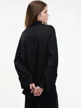 Camisa negra de viscosa con botones frontales y mangas largas.