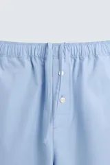 Pantalón de pijama celeste de algodón, corte relaxed fit, con cintura elástica ajustable con cordón interior, bolsillos laterales y detalle de vivos combinados a contraste en el bajo.