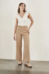 Pantalón wide leg color beige, de tiro alto, ligeramente ajustado en cintura y con ruedo desflecado.