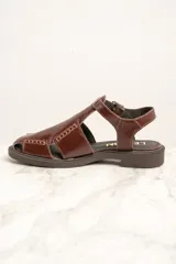 Sandalias de cuero marrón con diseño de tiras cruzadas y hebilla lateral.
