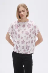 Remera blanca con estampado floral en color lila, de corte holgado y mangas cortas.