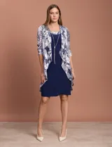 Conjunto de vestido azul marino con chaqueta estampada con motivos florales en tonos plateados y azules.