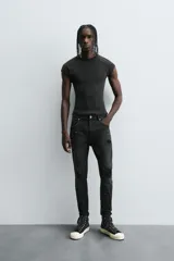 Pantalón de jean celeste de corte skinny con roturas en las rodillas y terminación desflecada.