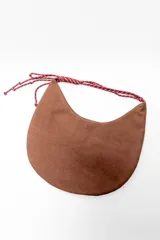 Bolso marrón con forma de media luna y asa de soga trenzada en rojo y blanco.