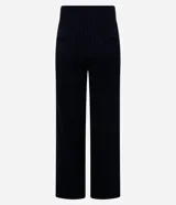 Pantalón recto de punto roma color negro con finas rayas verticales blancas. Tiene cintura alta con hebillas plateadas en los laterales.