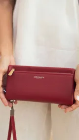 Billetera de mujer color verde oliva, con textura símil cuero, cierre principal y bolsillo monedero con cierre al frente. Incluye correa de mano desmontable y tarjeteros internos.