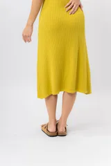 Vestido midi verde oliva de tejido acanalado, con escote en V y silueta al cuerpo con caída fluida.