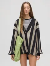 Cardigan a rayas horizontales en tonos beige y negro, de corte holgado y abierto, con botones metálicos y logo MUTMA bordado en el frente.