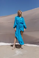 Conjunto de camisa celeste de mangas largas abullonadas y falda turquesa con detalle fruncido y lazo en el lateral.
