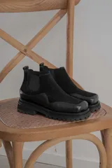 Botas Chelsea de cuero color marrón con paneles laterales elásticos negros y suela track de goma negra.