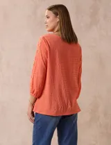 Blusa blanca texturada marca Ruby Rd, con escote redondo y mangas 3/4 con puño elastizado y apliques de broderie. Confeccionada en poliéster y elastano.