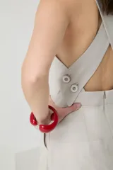 Mono color beige con breteles anchos, corte a la cintura con botón decorativo y pantalón palazzo con diseño cruzado.